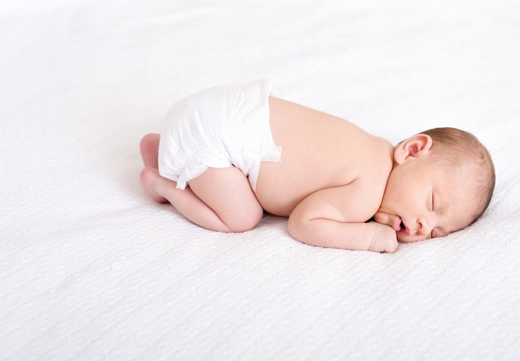 Schlafendes Baby auf weißem Musselin Tuch